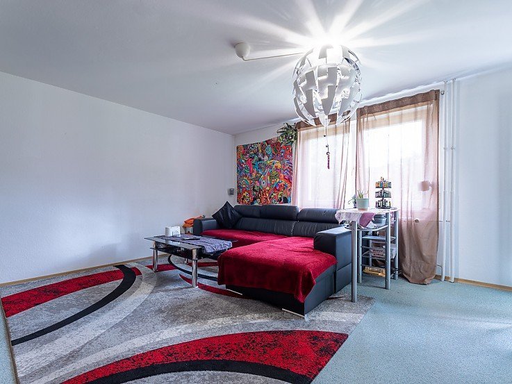 Ger�umiges Wohnzimmer mit gro�er Couch und Teppich in der 3-Zimmer-Wohnung am St.-Mang-Weg in Kaufbeuren - erfolgreich verkauft durch Stockhausen Immobilienteam
